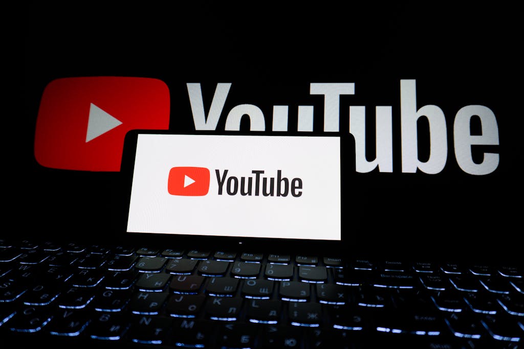9 Brilliant Inventions That Actually Made Society Worse 1 Close-up of YouTube logo displayed on a laptop screen in a dark environment.