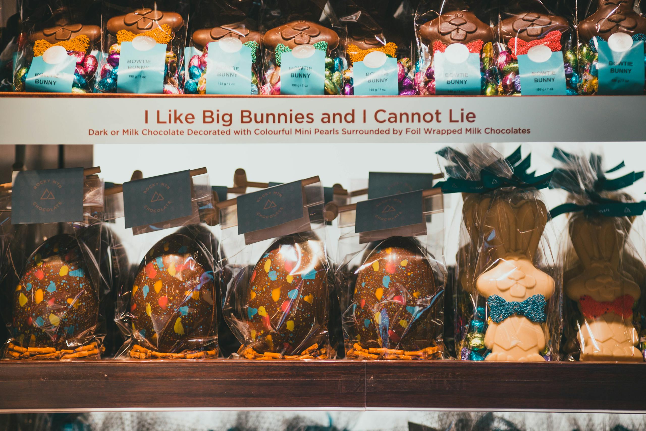 Colorful Easter display with chocolate bunnies and eggs decorated with mini pearls and foil wrap.