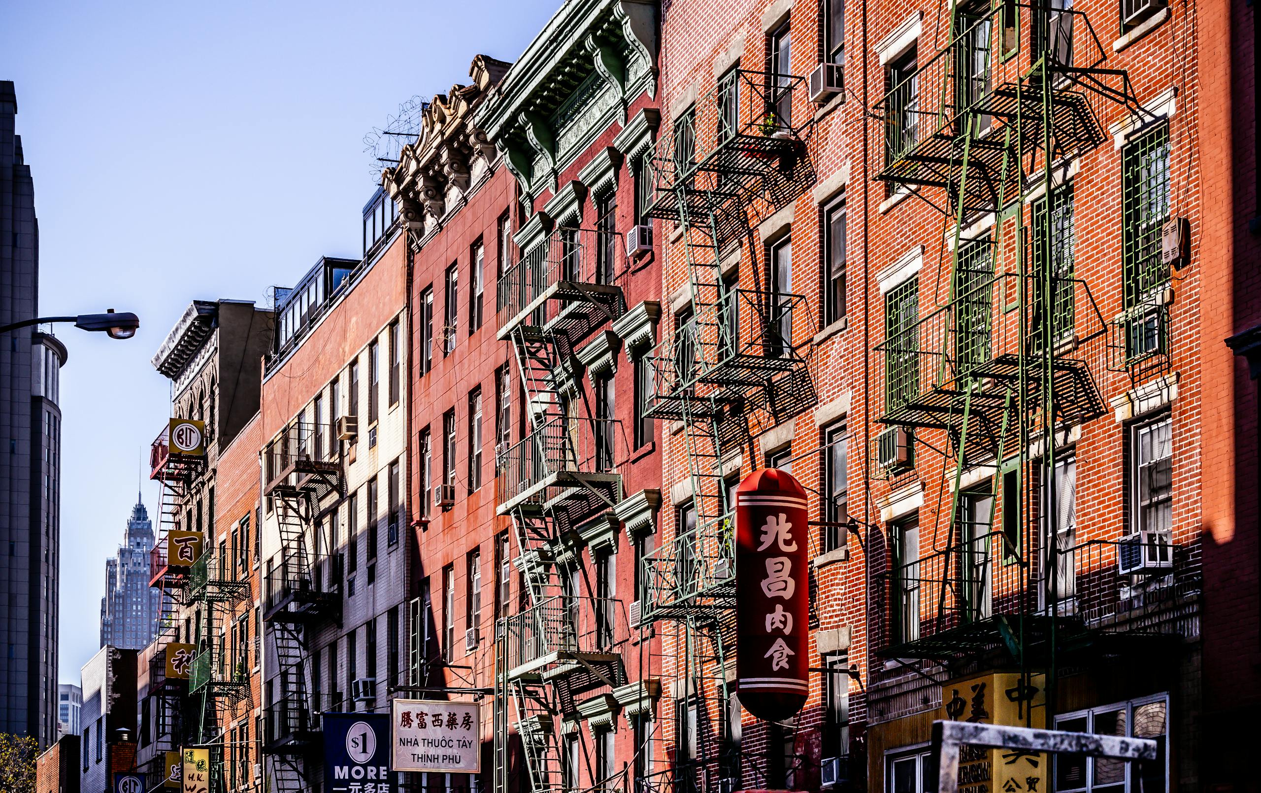 Colorful fire escape lined buildings in New York City's Chinatown vibrant street scene.