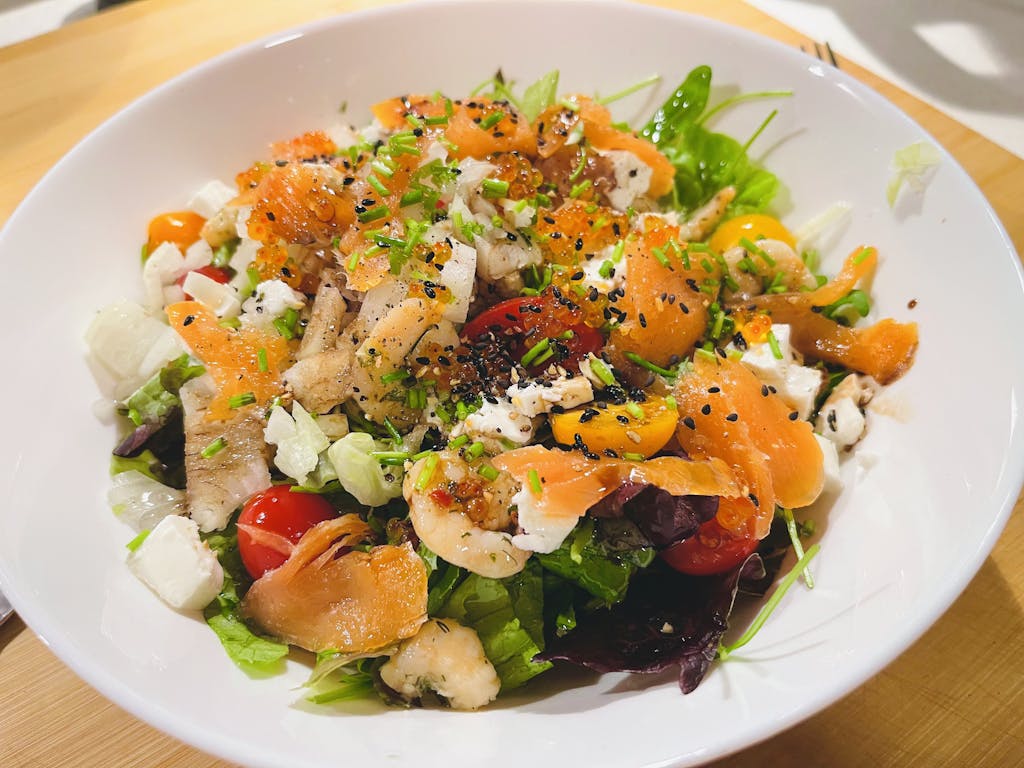 Colorful seafood salad with smoked salmon, prawns, and fresh vegetables perfect for a nutritious meal.