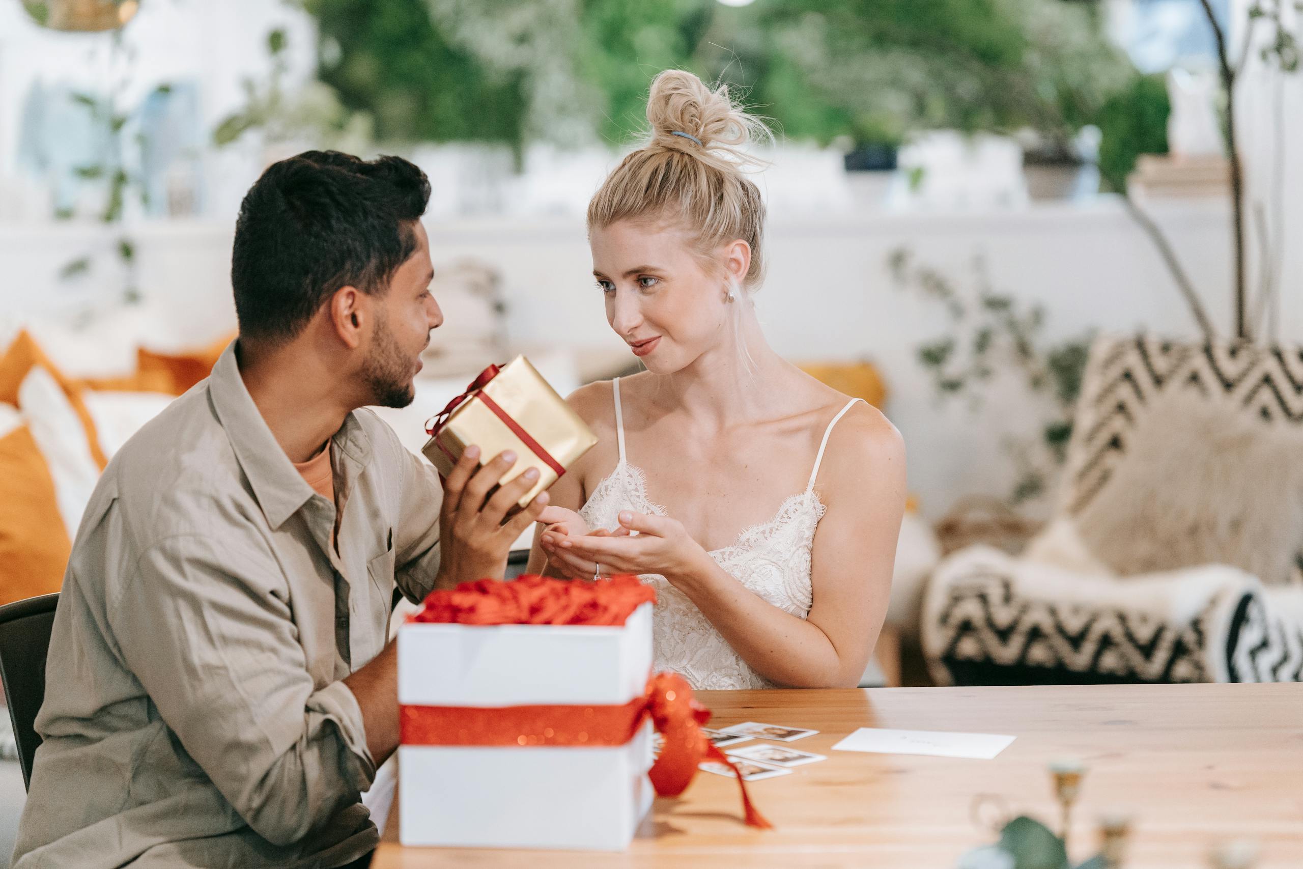 Couple exchanging gifts indoors, highlighting love and togetherness.