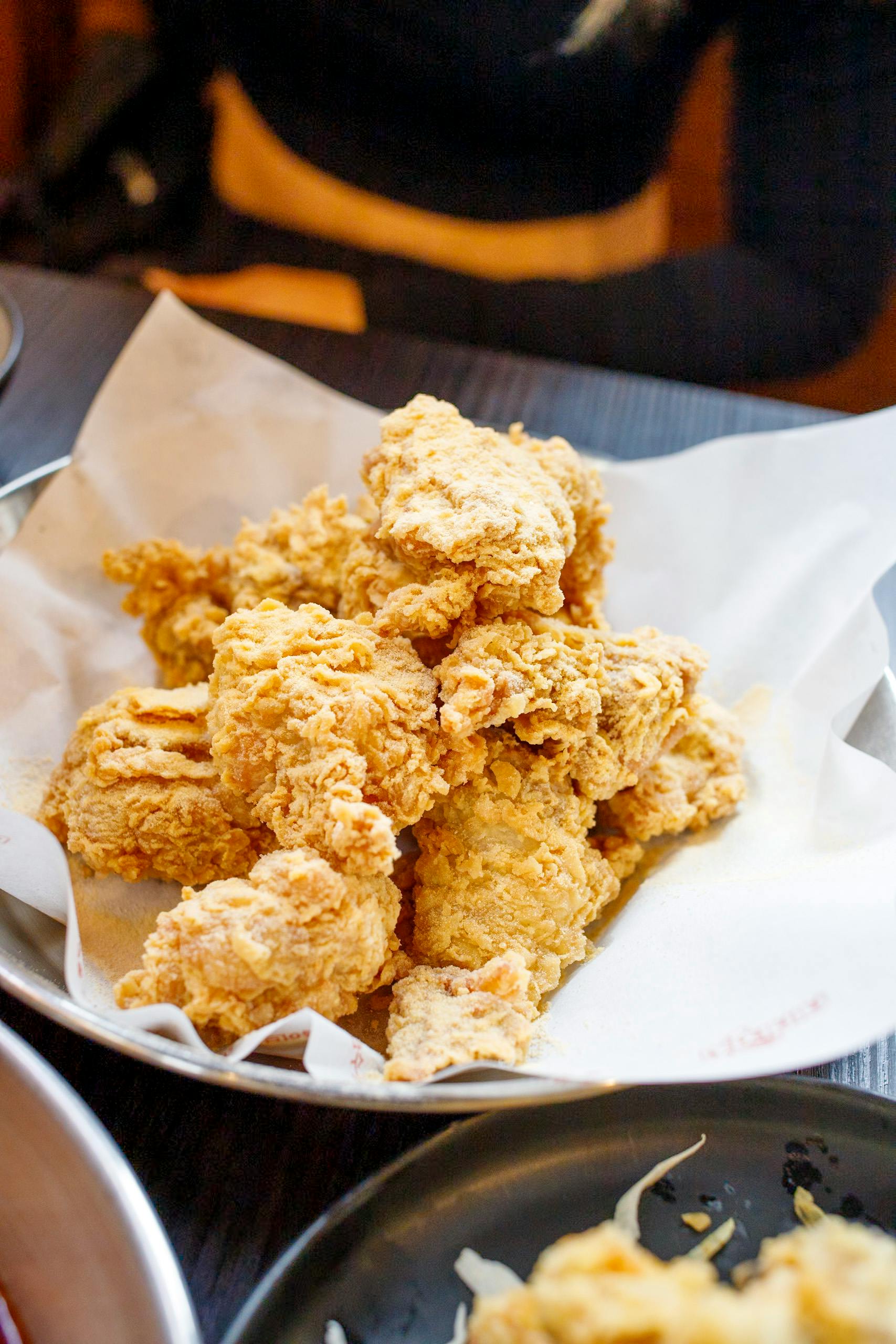 Delicious crispy fried chicken served on a paper-lined plate, ready to enjoy.
