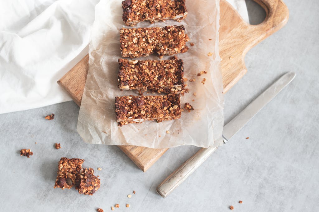 Delicious homemade granola bars on a wooden board, perfect for healthy snacking and meal preparation.