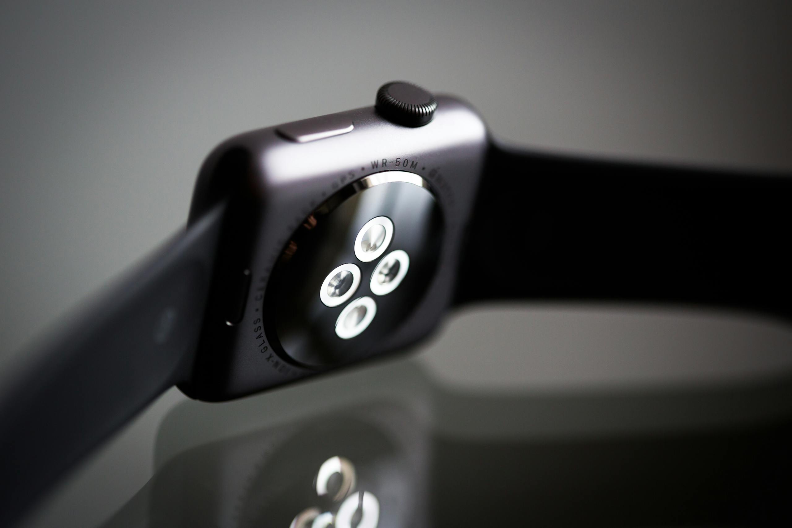 Detailed image of the back sensor of a modern smartwatch showing reflective surface and technology focus.