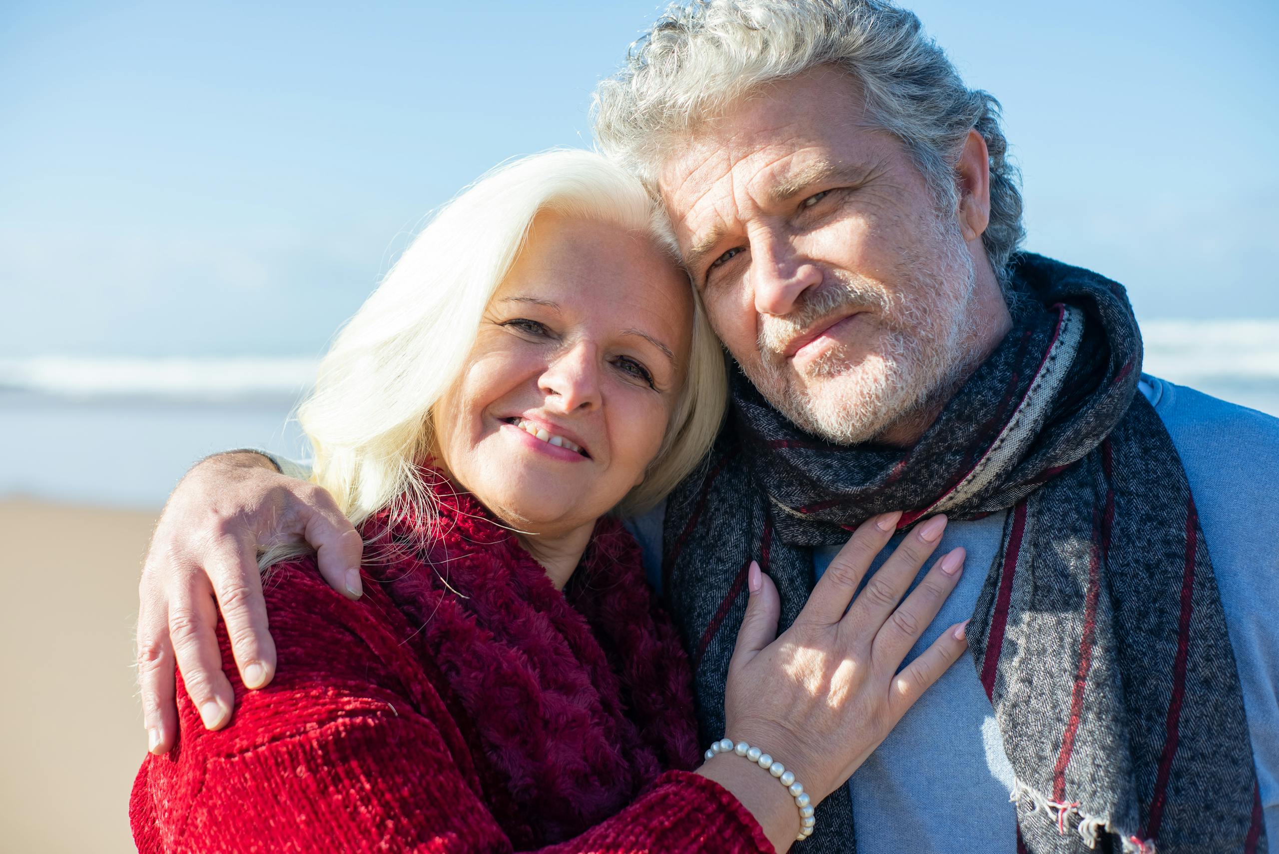 Elderly couple sharing a joyful moment by the beach in Portugal, showcasing love and togetherness.