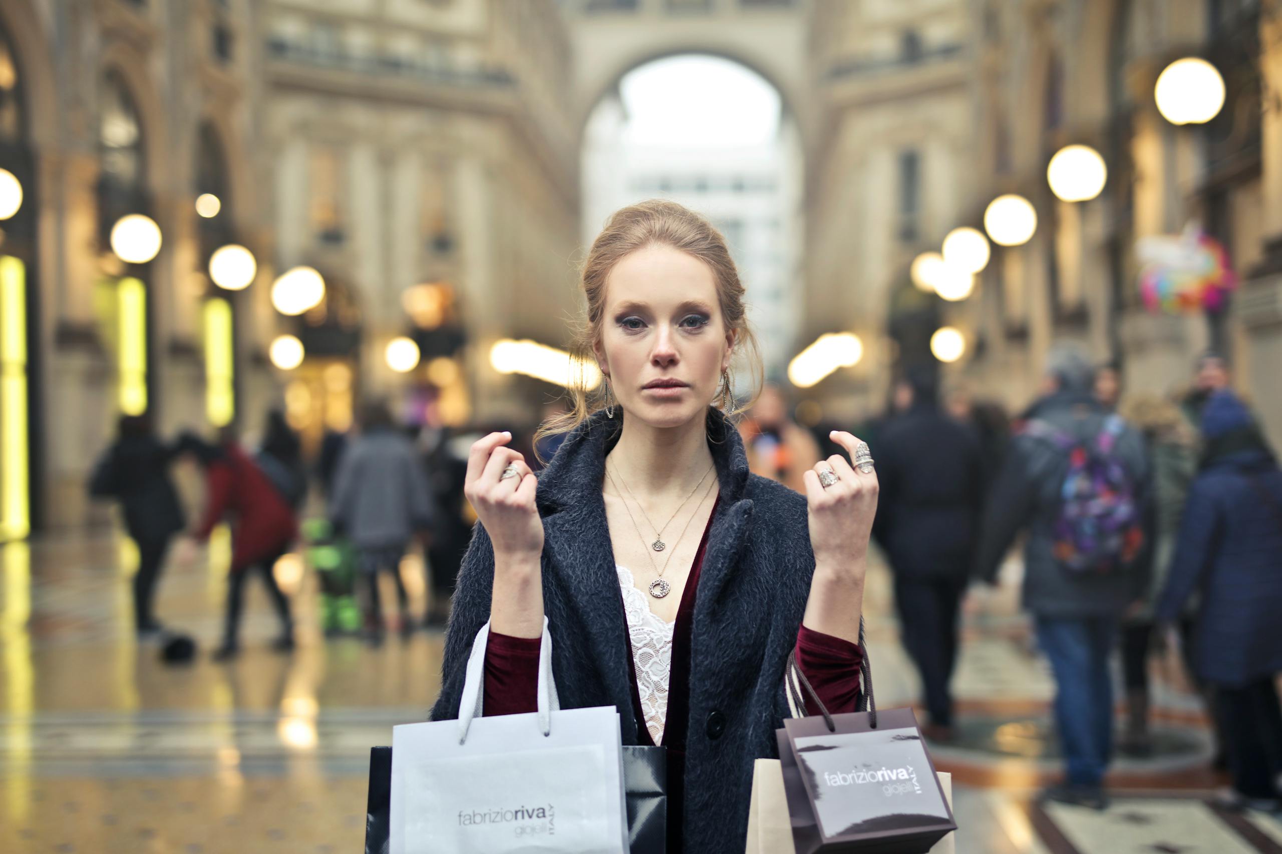 Elegant woman shopping with bags in Milan's iconic Galleria Vittorio Emanuele II.
