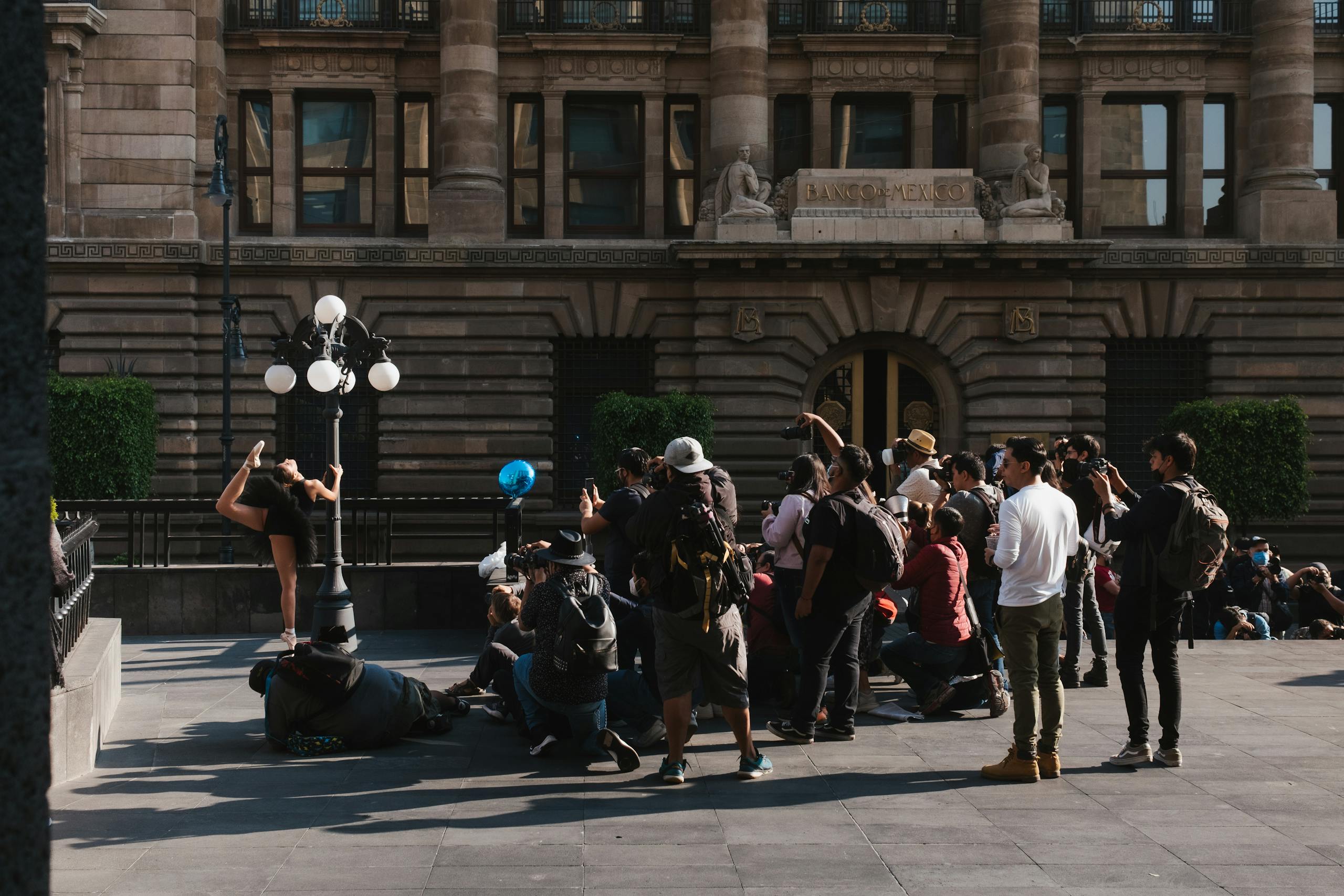 Energetic street performance with photographers capturing the moment outside Banco building.
