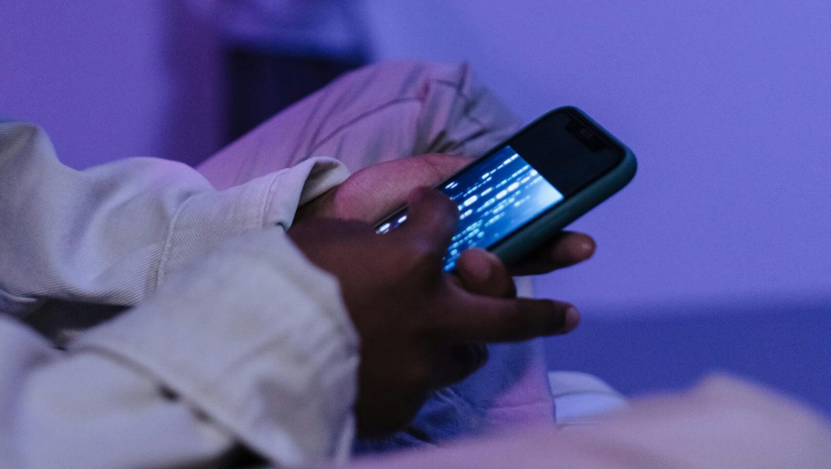 Focused teens using smartphones indoors, creating a modern tech atmosphere.