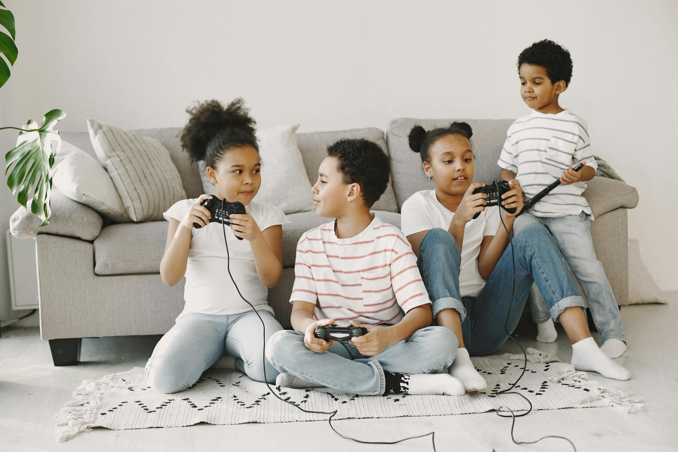 Four children playing video games together in a cozy living room setting.