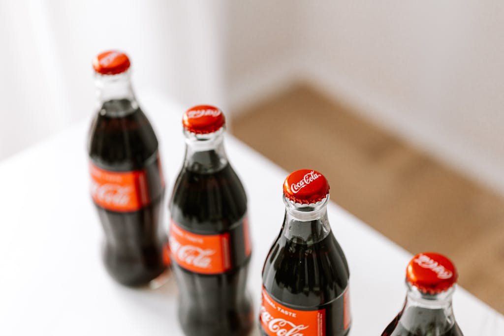 Stop Eating These 8 Fast Foods Before They Damage Your Blood Sugar 2 From above of full bottles of coke placed in row on white table