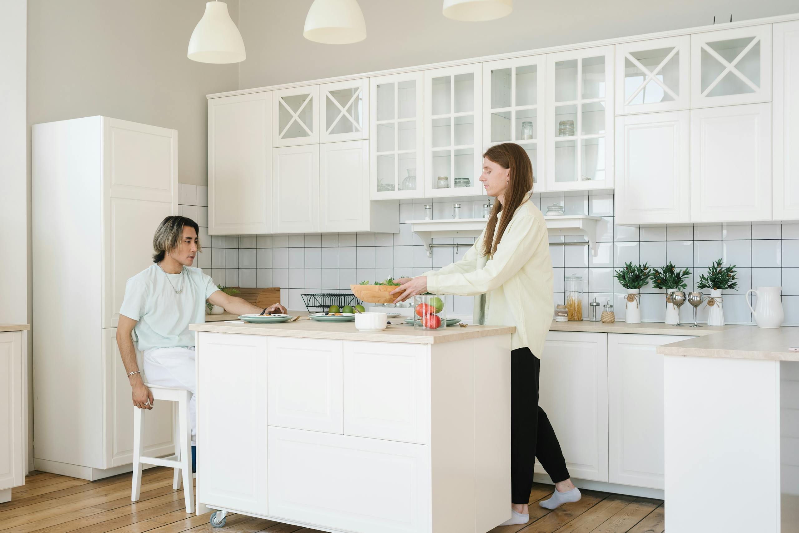 Interracial couple preparing a healthy meal together in a bright, modern kitchen setting.