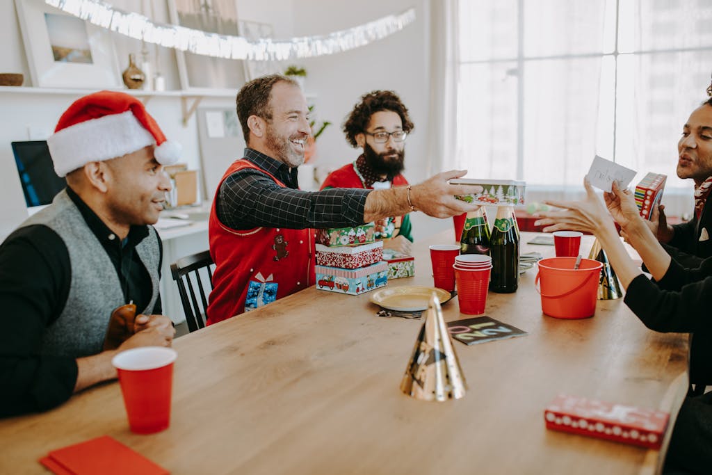 Joyful Christmas party with friends exchanging gifts indoors, creating holiday cheer.