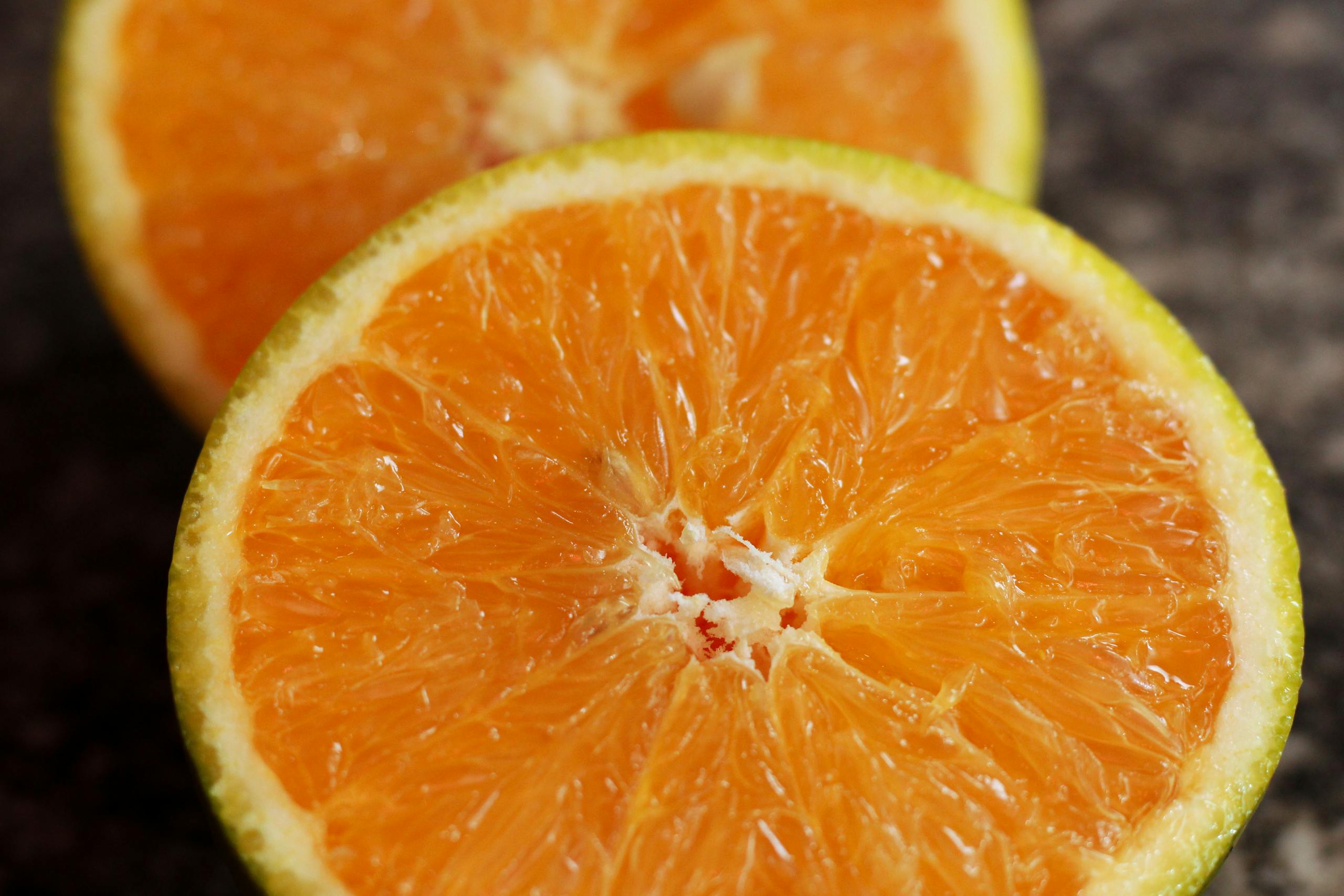 Juicy sliced oranges on a textured surface, showcasing vibrant orange hues.