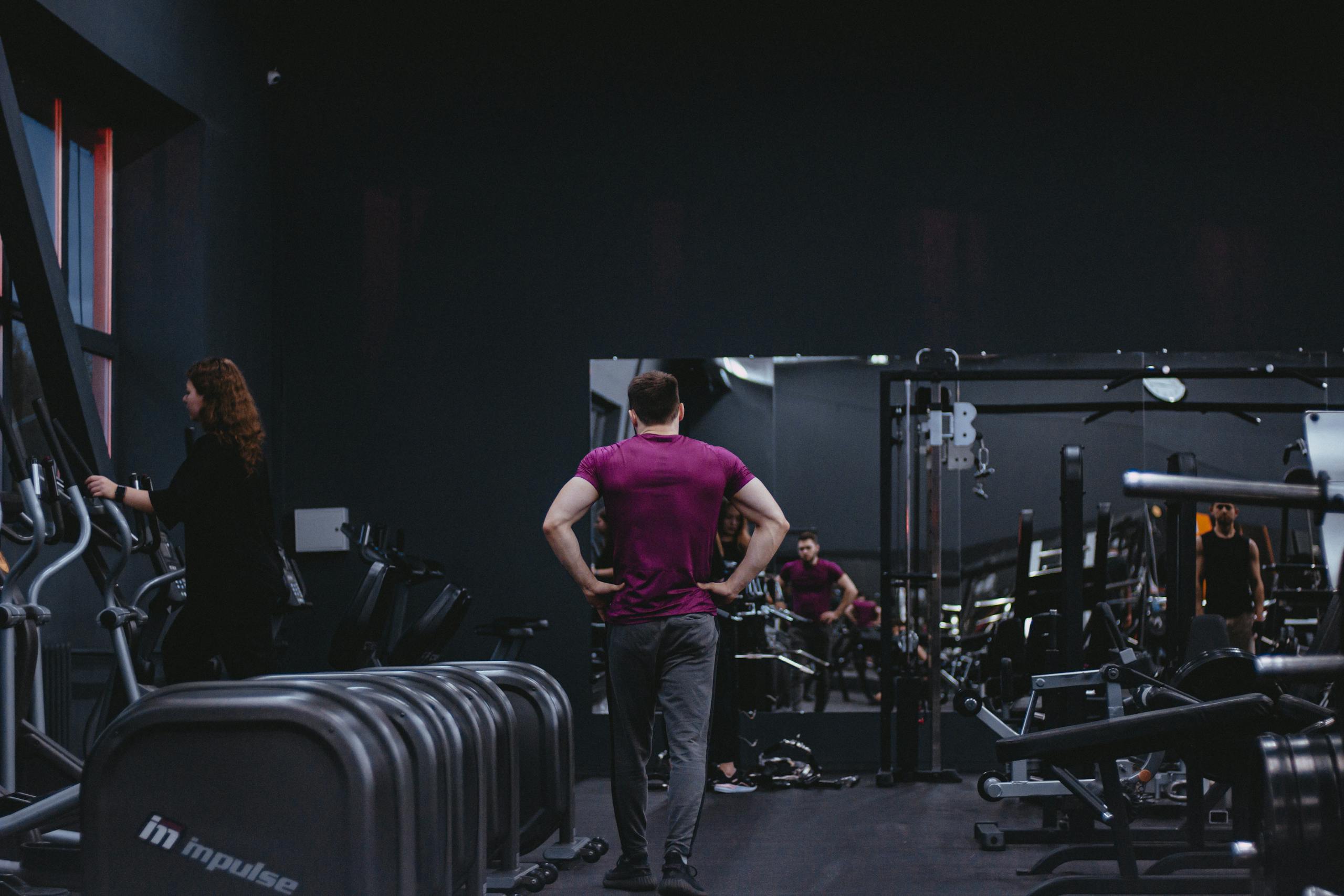 Man in a gym with fitness equipment, highlighting a healthy lifestyle.