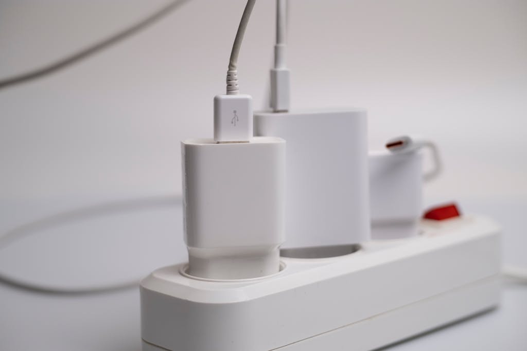 You’re Throwing Away Money on Electricity Because of These 8 Mistakes 4 Minimalist composition of electronic device chargers connected to a power strip indoors.