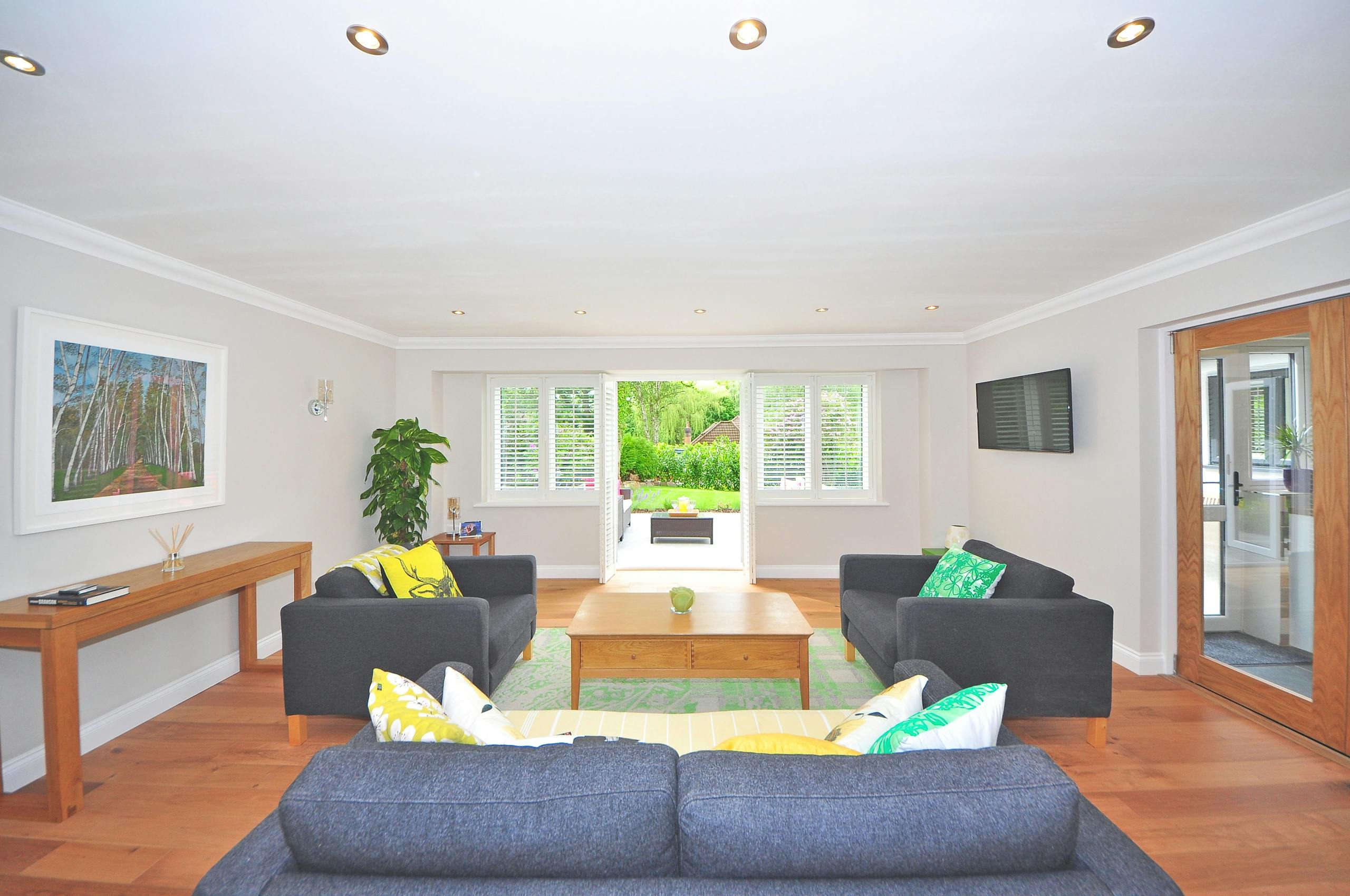Modern living room with stylish furniture, wooden flooring, and bright decor in a spacious layout.