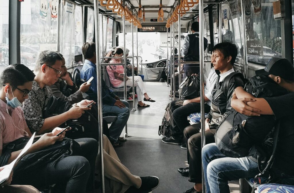 Passengers occupy seats inside a city bus as it moves through an urban area, showcasing daily commute life.