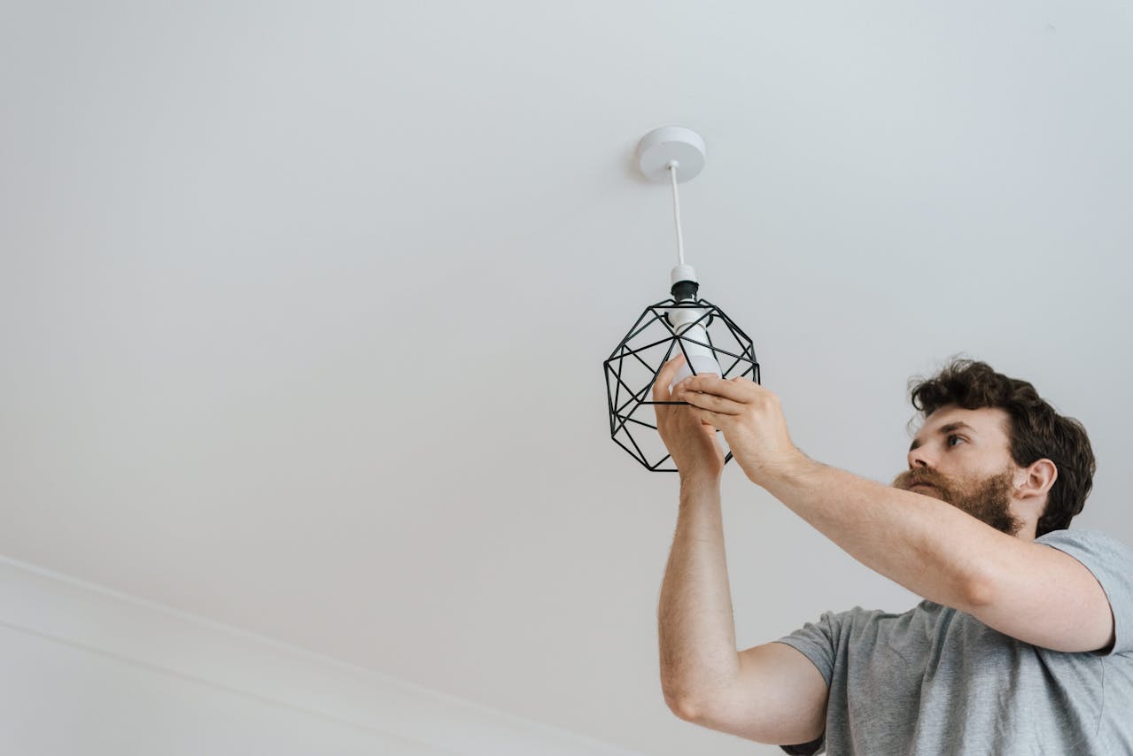man-screwing-light-bulb-into-lamp-