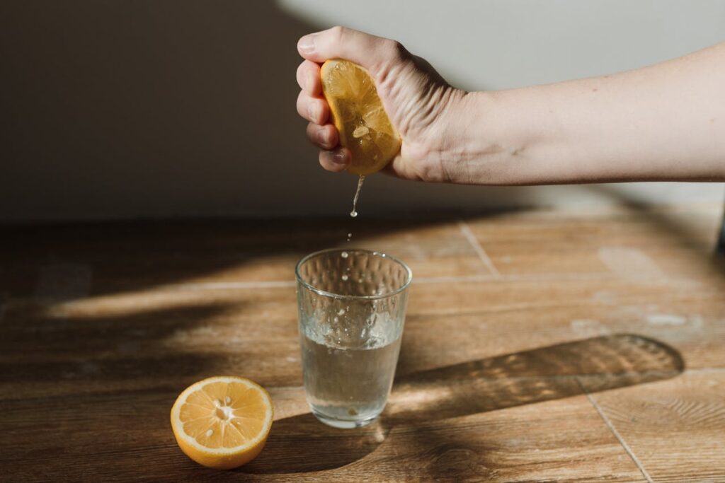 /close-up-shot-of-a-person-squeezing-a-lemon-