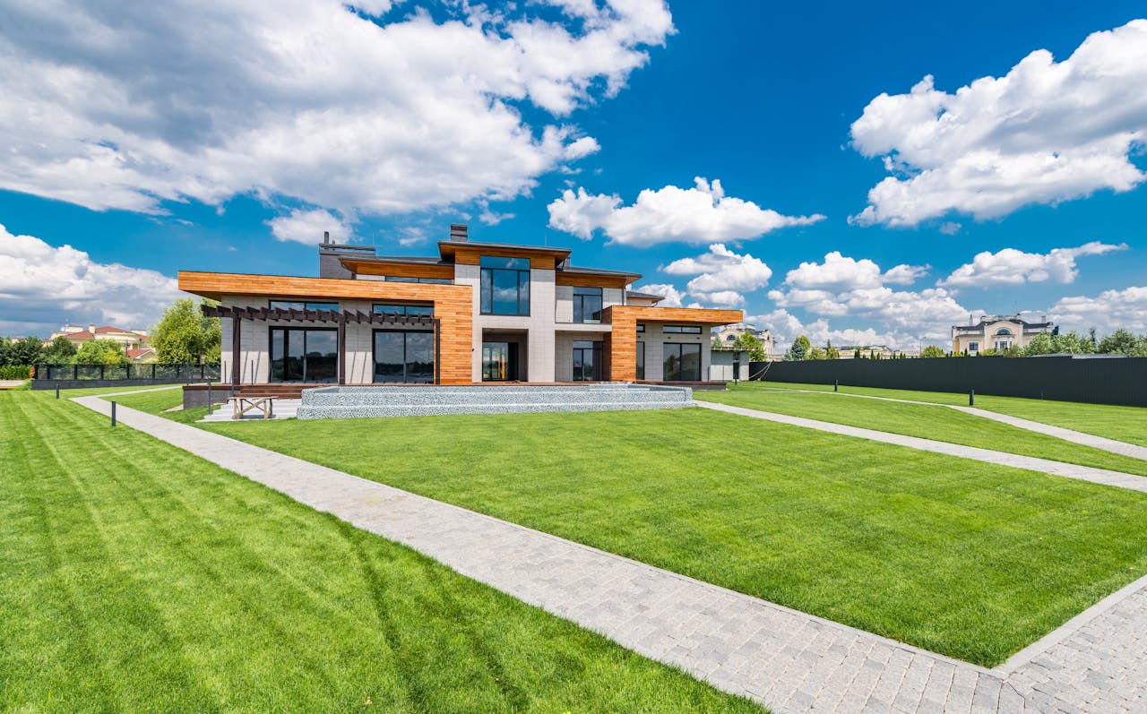landscape-with-modern-residential-house-against-cloudy-sky-7031602/