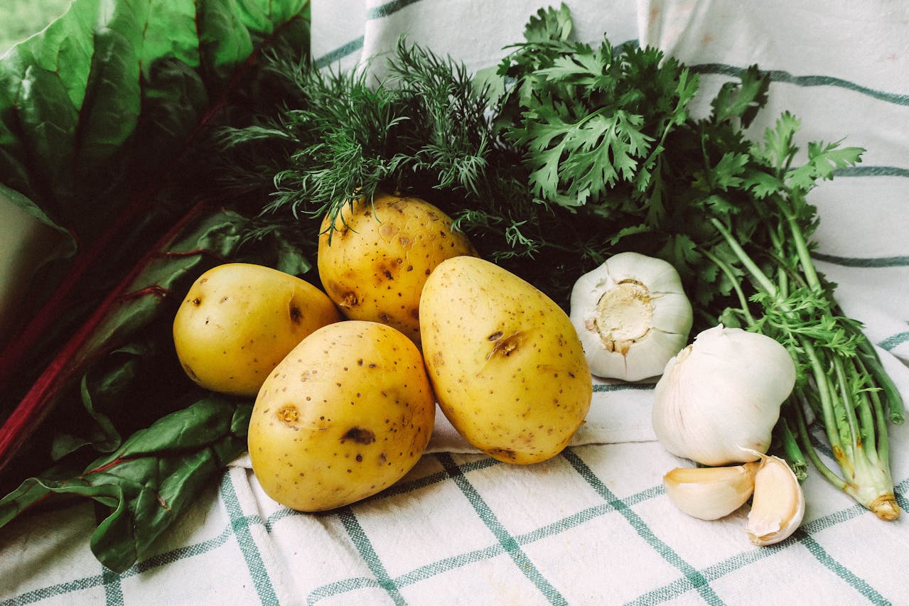 close-up-of-fresh-potatoes-garlic-and-parsley-on-a-kitchen-cloth-
