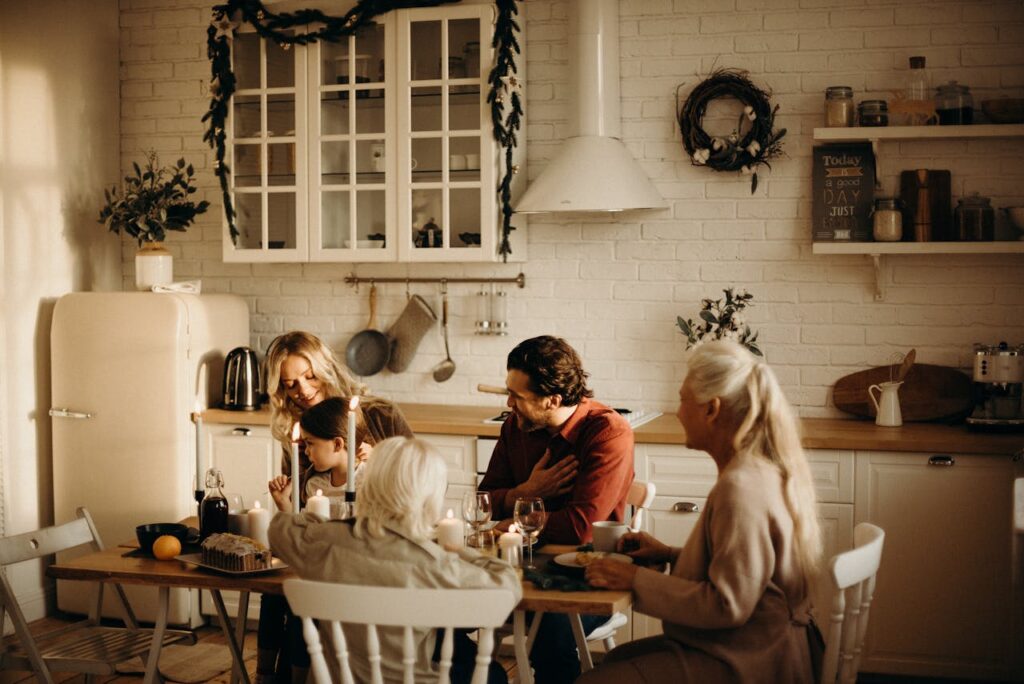 family-sits-on-table-inside-kitchen-