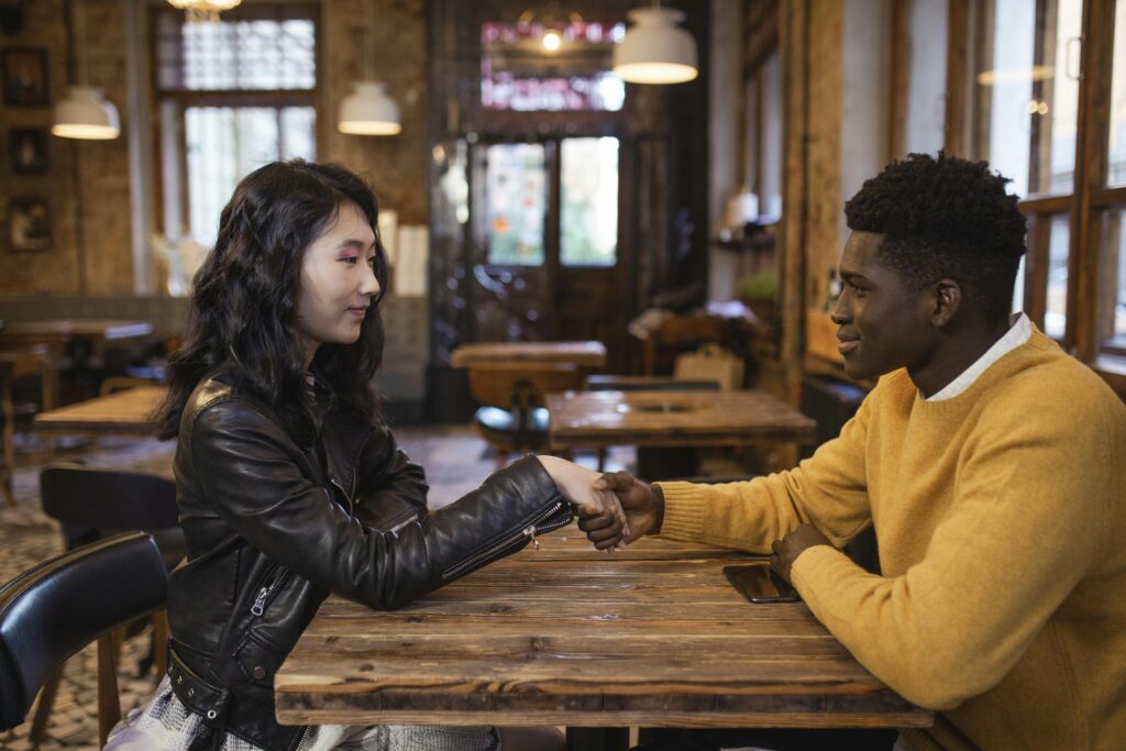 a-man-and-woman-sitting-near-the-wooden-table-while-holding-hands-