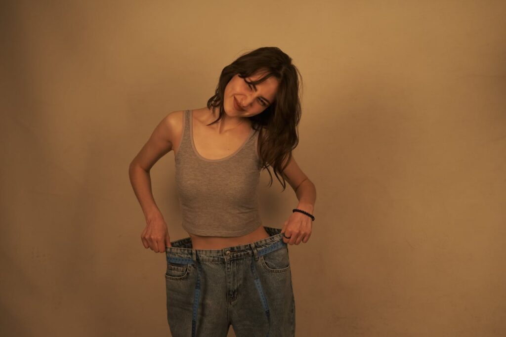 young-woman-showing-weight-loss-success-