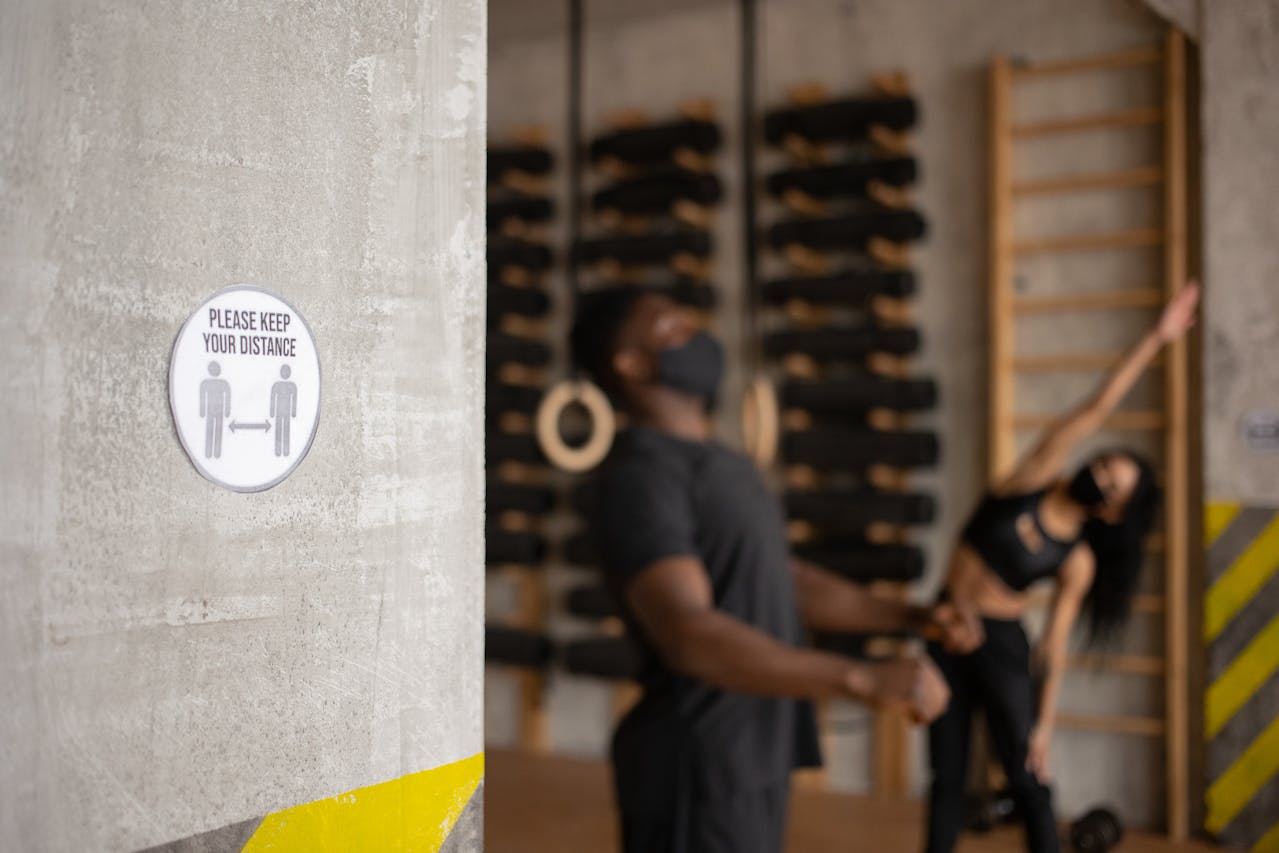distance-sign-in-gym-with-unrecognizable-black-sportspeople-during-workout