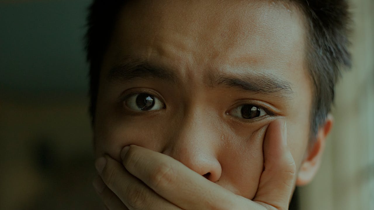 /close-up-of-a-person-covering-their-mouth