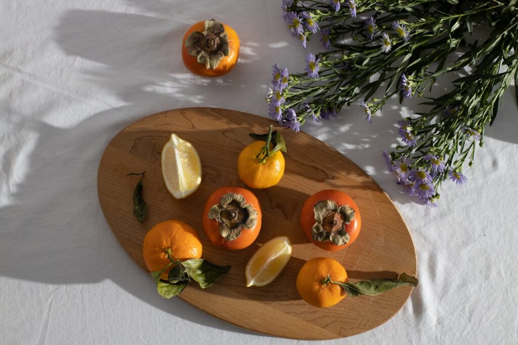 /fresh-ripe-citruses-and-persimmon-composed-with-bunch-of-european-michaelmas-daises-