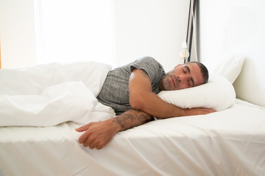 /man-in-gray-shirt-lying-on-the-bed-