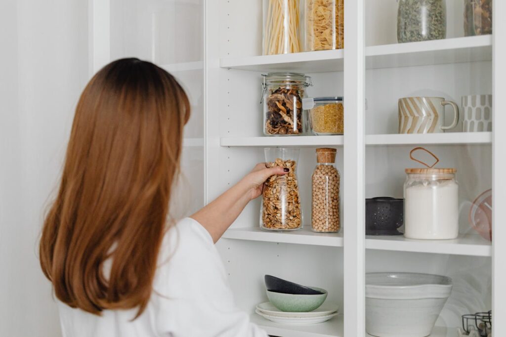 a-woman-in-white-shirt-holding-clear-glass-jar-