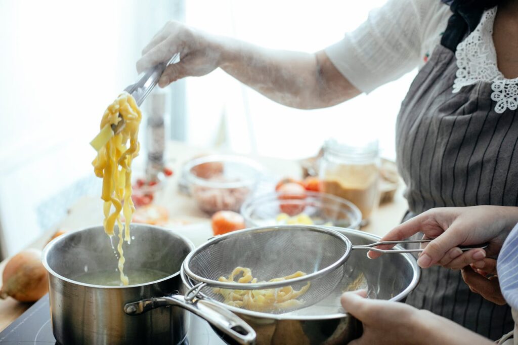 women-cooking-pasta-in-kitchen-