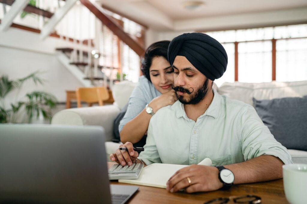 indian-couple-counting-bills-on-calculator-