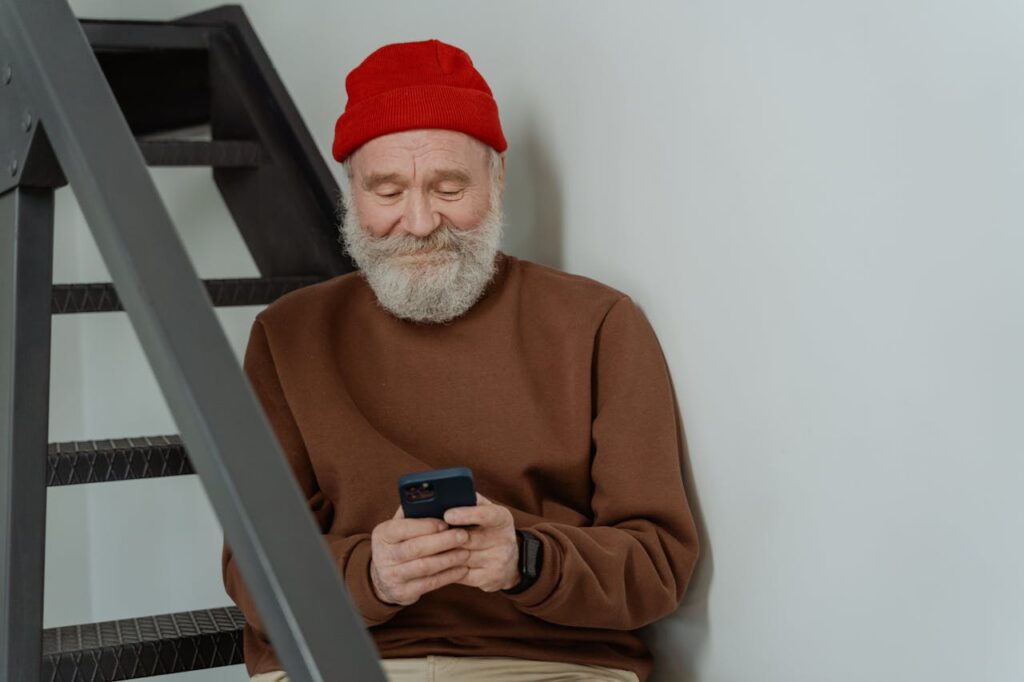 /man-in-brown-sweater-holding-a-smartphone