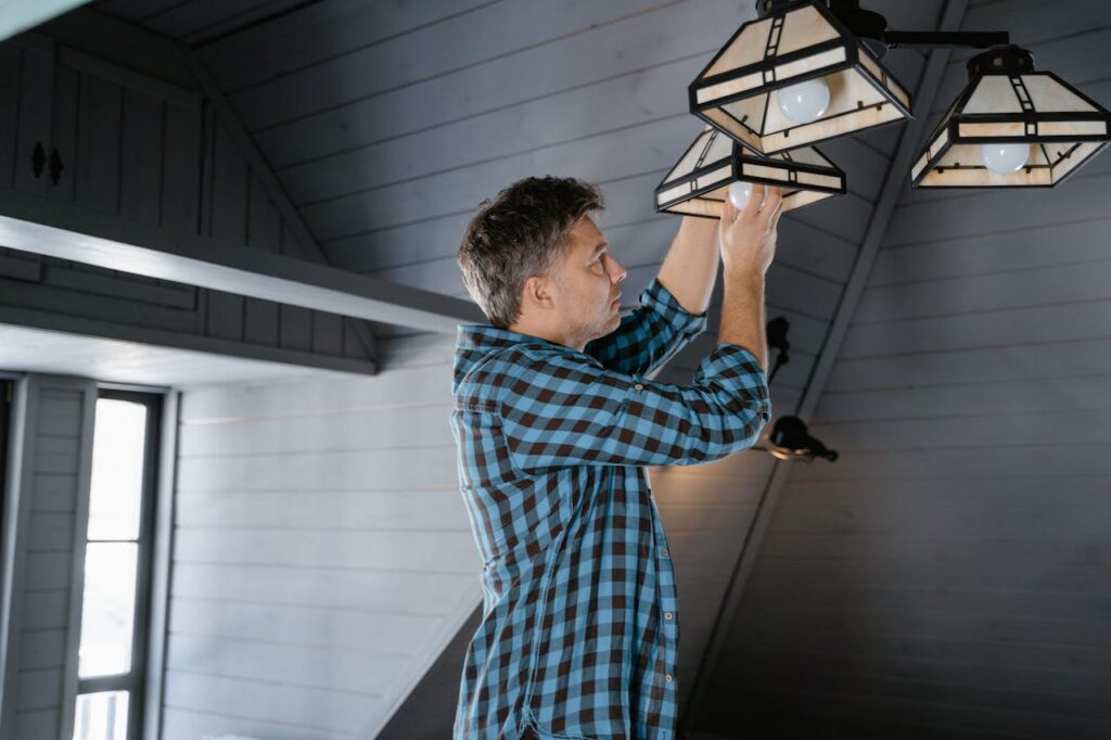 person-in-plaid-shirt-putting-a-light-bulb