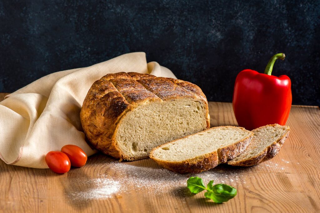 /fresh-sourdough-bread-pepper-tomatoes-and-basil-on-a-wooden-table-