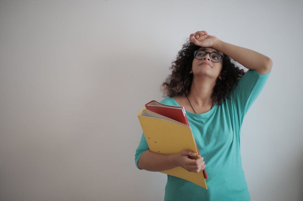overworked-adult-female-entrepreneur-with-papers-in-light-modern-office-