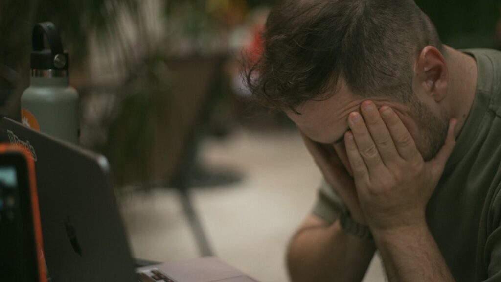 man-stressed-while-working-on-laptop-indoors