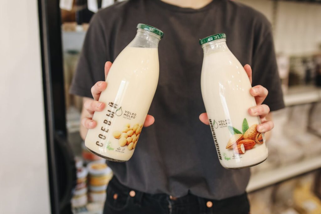 person-holding-bottles-with-milk-