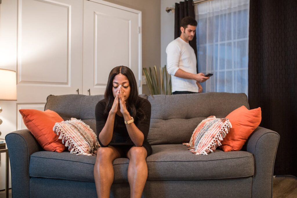 a-woman-sitting-on-the-sofa-while-a-man-is-standing-at-the-back-