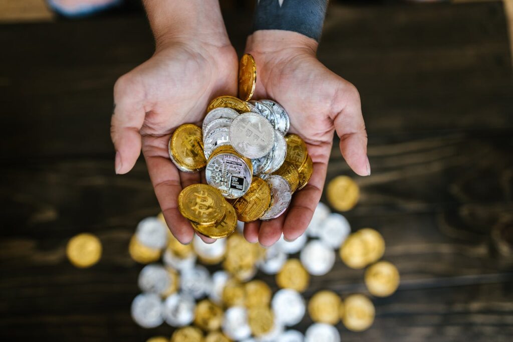 close-up-shot-of-person-holding-gold-and-silver-bitcoins-