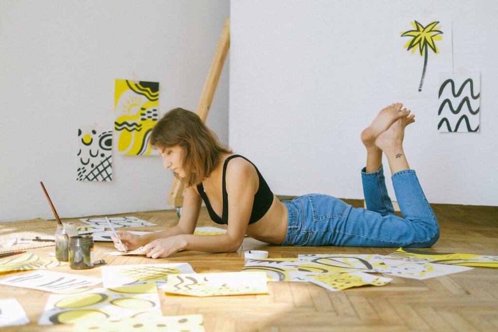 photo-of-woman-lying-on-floor-while-painting