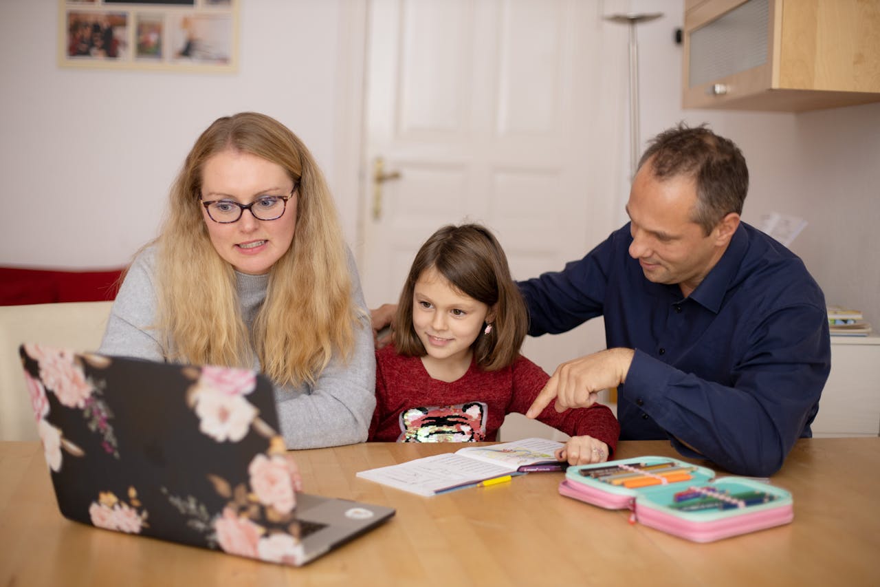 parents-helping-their-daughter-with-home-schooling-