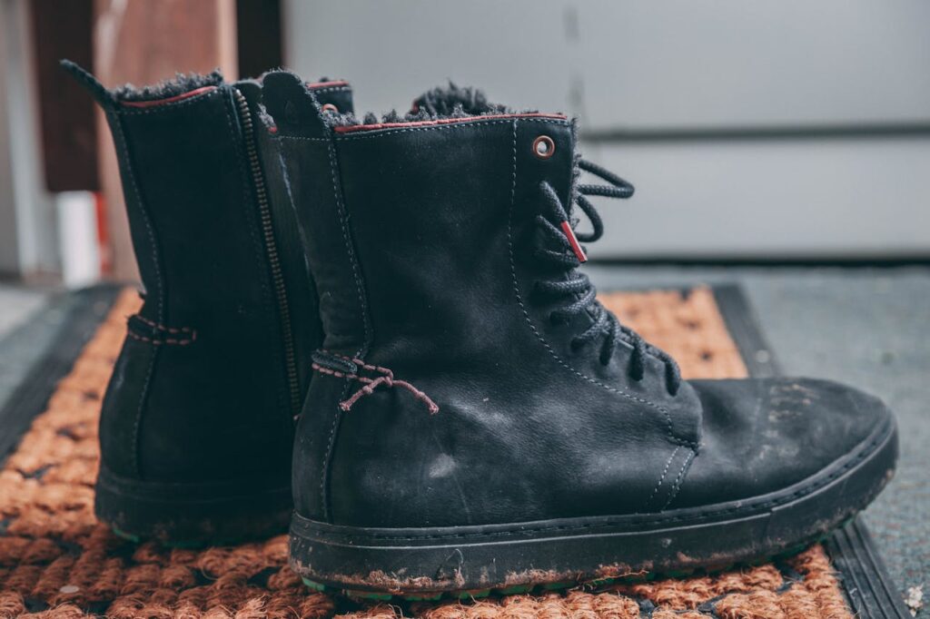 pair-of-black-lace-up-boots-on-area-rug