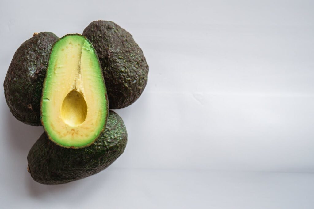 pile-of-ripe-bright-avocados-on-white-table