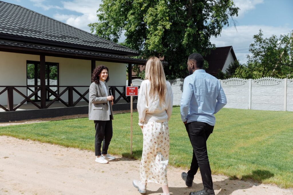 a-couple-walking-towards-the-woman-standing-beside-a-wooden