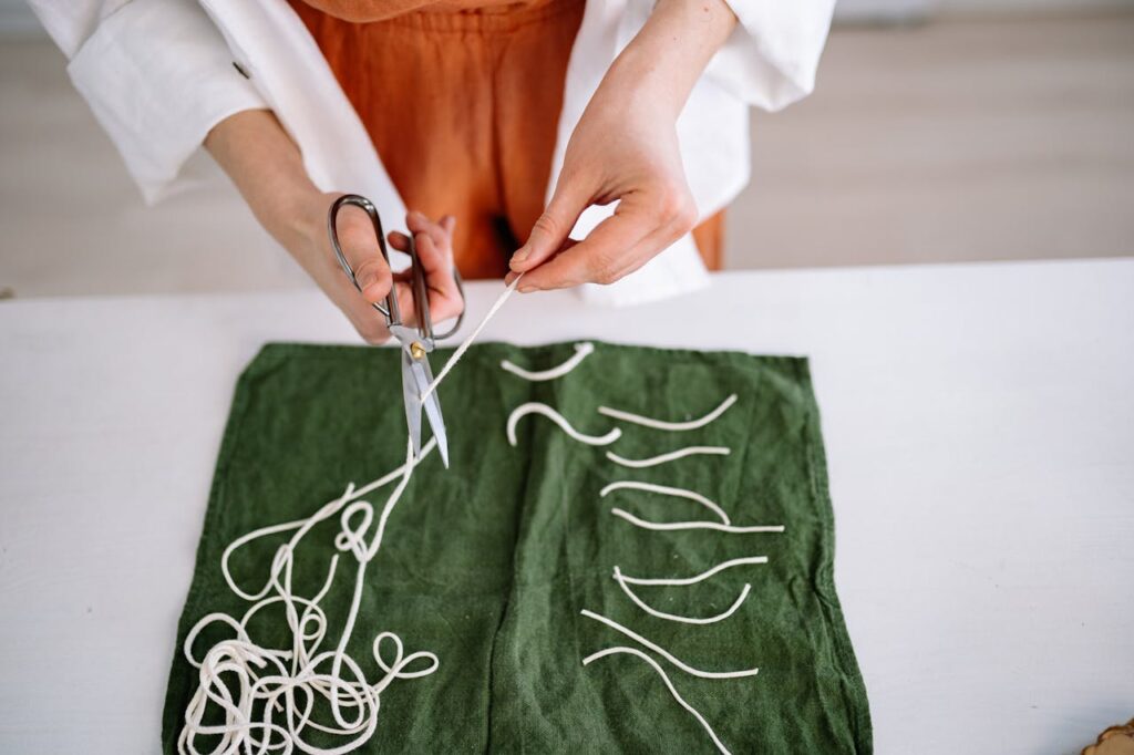 /person-cutting-the-wicks-as-preparation-for-candle-making