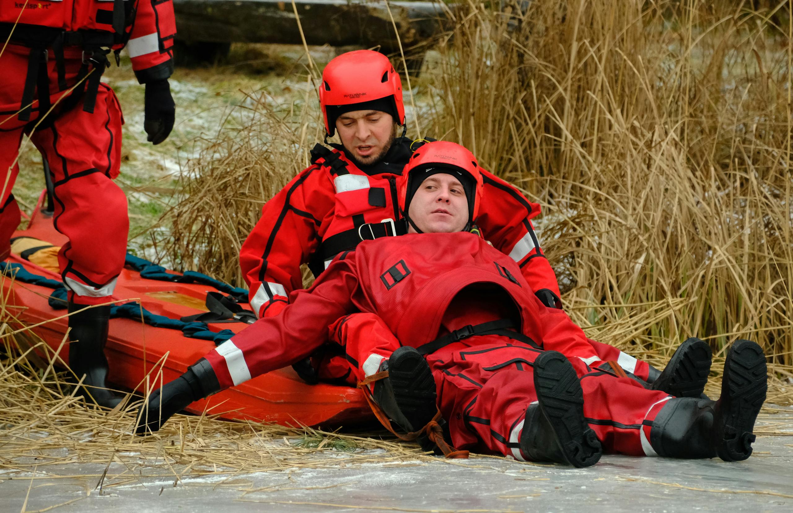 Rescue team conducting an ice water rescue operation with safety equipment in cold weather.
